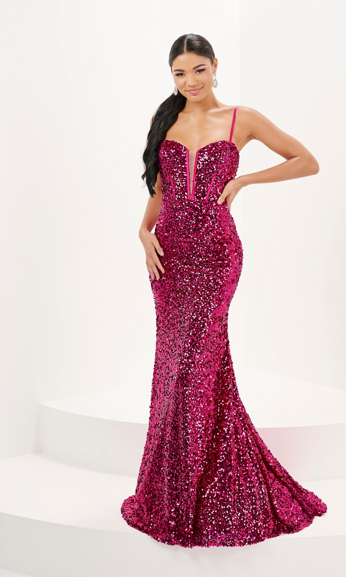 Model poses in the Tiffany V-Neck Fitted Long Sequin Prom Dress 16081, a floor-length hot pink gown with dazzling sequins, thin straps, a deep V neckline, and elegant corset boning, set against a white background.